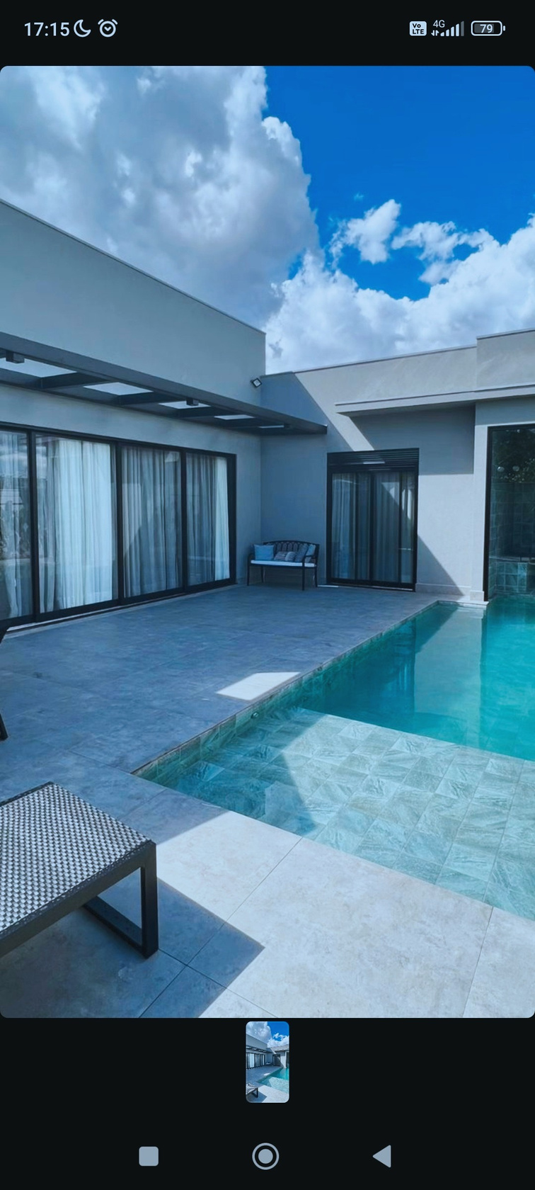 Pátio com piscina e portas de vidro deslizantes em fachada residencial